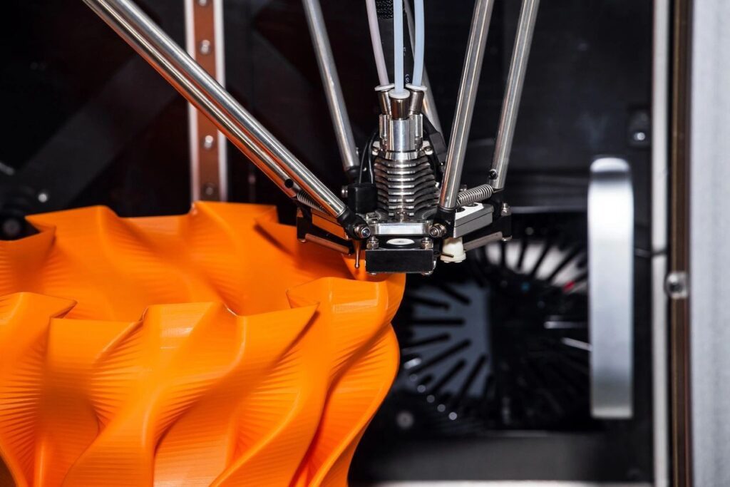 A close up of an orange object in the process of being printed.