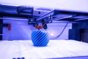 A blue object being printed on the 3 d printer.
