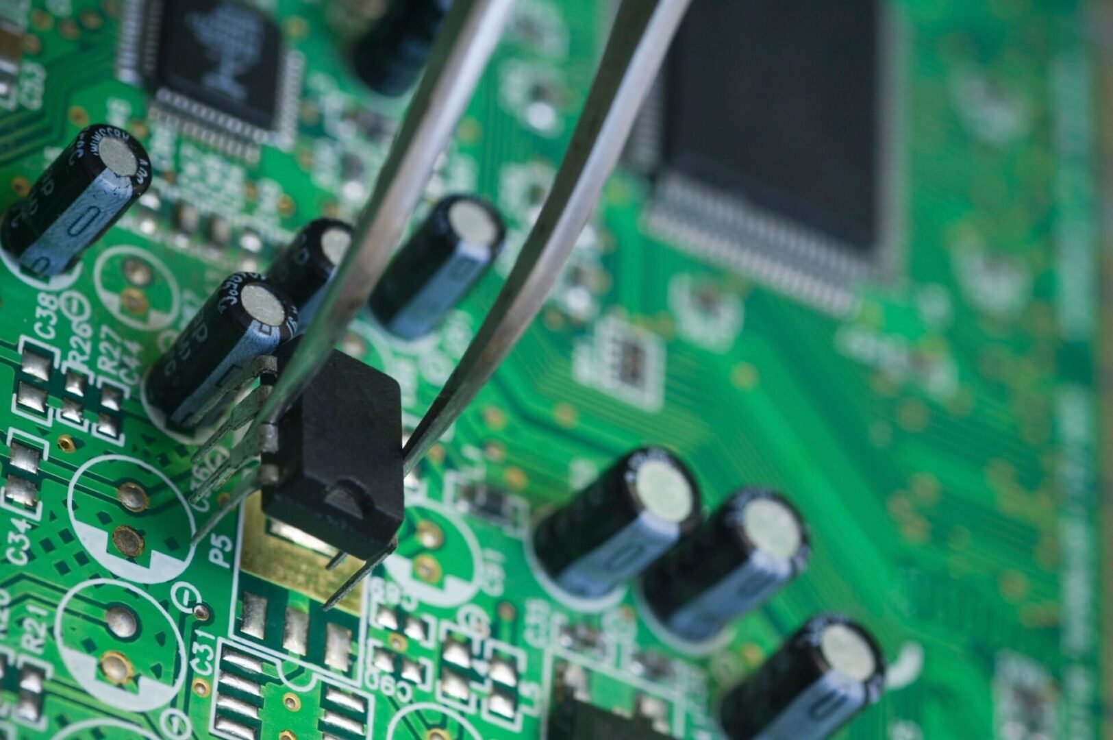 A close up of a circuit board with soldering tools